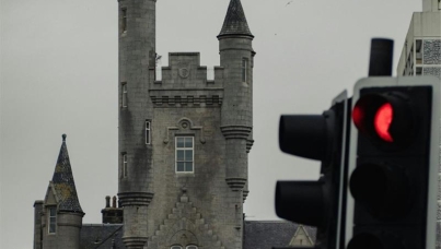 A traffic light in front of a large building