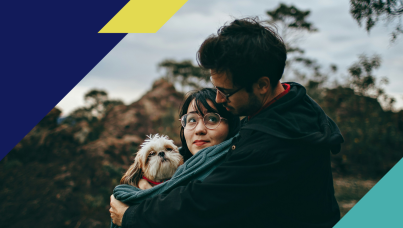 Couple hugging while holding a dog