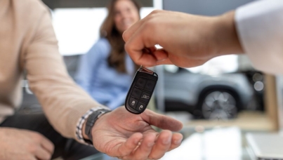 A person handing a car key over to a customer