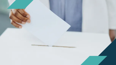 A hand casting a ballot into a box