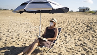 Woman wearing face mask at the beach | consumers' priorities | Ipsos