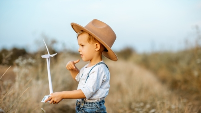 Kind hält Windrad-Attrappe