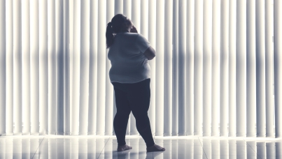 Person with obesity looking through window