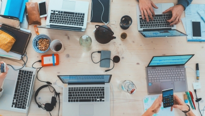 people-sitting-down-near-table-with-assorted-laptop-computers
