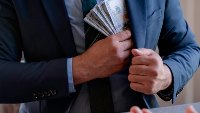 homem colocando dinheiro no paletó