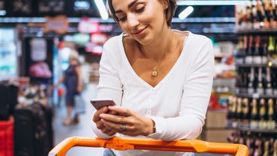Mulher no mercado mexendo no celular