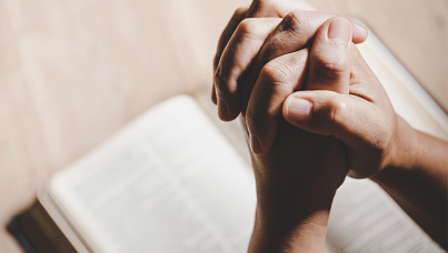 Mãos juntas sobre a bíblia