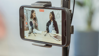 Celular gravando 2 mulheres em um podcast