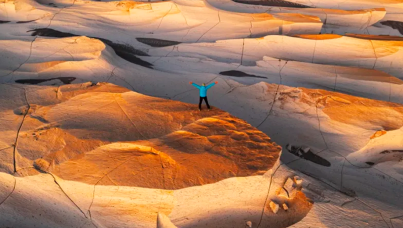 Pessoa em um deserto com os braços abertos
