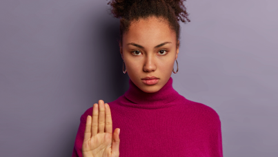 Mulher séria com a mão levantada
