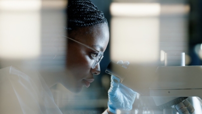 A woman looking through a microscope