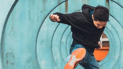 A young man kicks at the air