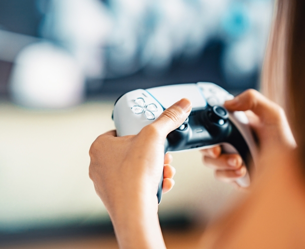 Eine Person die einen weißen Gaming-Controller bedient.