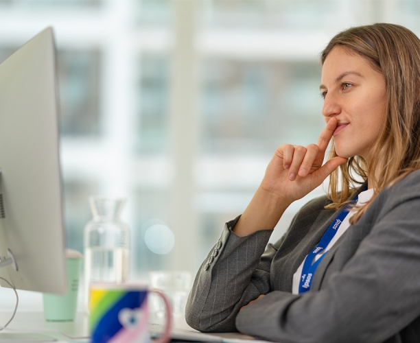 Clarissa Quiring, Marketing & Communications, Ipsos in Deutschland, in der Seitansicht, sitzt am Schreibtisch schaut auf einen Computermonitor