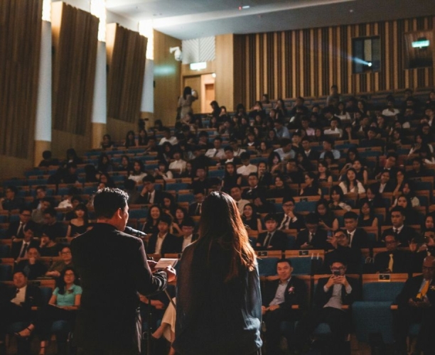 two people presenting to a large room