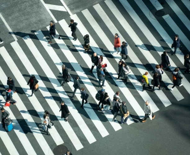 An aerial view of a crowd of people crossing a road