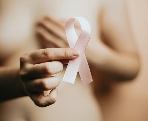 woman holding a pink breast cancer awareness ribbon