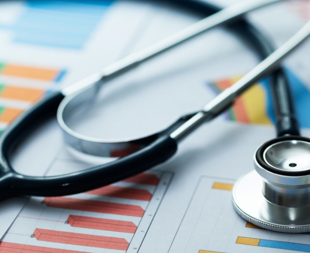 Stethoscope resting on bar charts