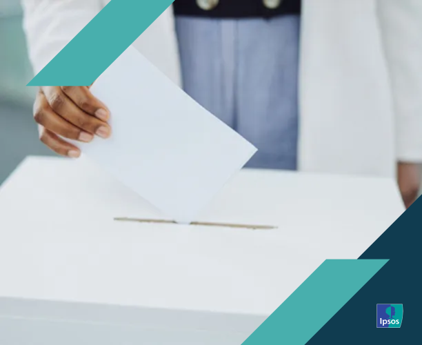 A hand casting a ballot into a box