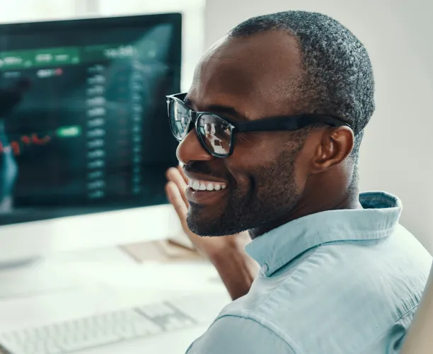 data analyst smiling at his desk