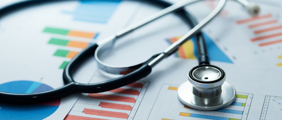 Stethoscope resting on bar charts