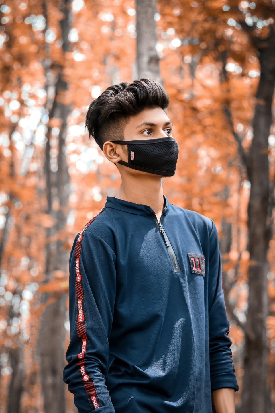A boy in a forest with a face mask on