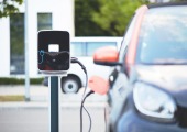 electric car charging station, connected to a black car (blurred)