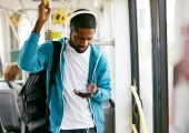 Guy on tram listening to radio