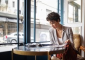 Woman reads the newspaper in a coffee shop