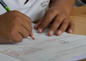 Pupil writing in a classroom